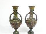 two vases that are sitting side by side on a white surface