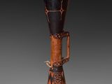 a close up of a wooden vase with a black and brown design on it