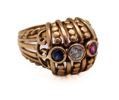 un gros plan sur une bague en or sertie de pierres de différentes couleurs