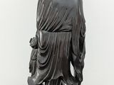 a statue of a man with a hat on a wooden table