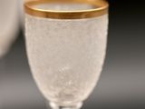 a wine glass with a gold rim sitting on a table