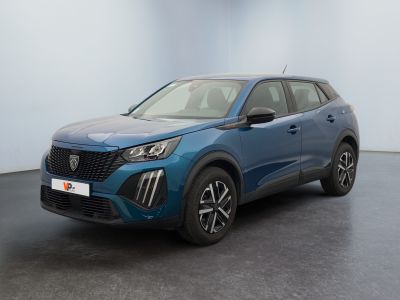 une voiture bleue garée dans une pièce aux murs blancs
