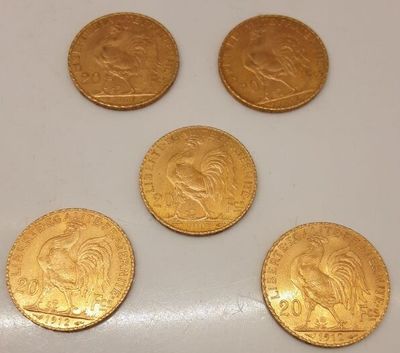 quatre pièces d'or sont posées sur une surface blanche