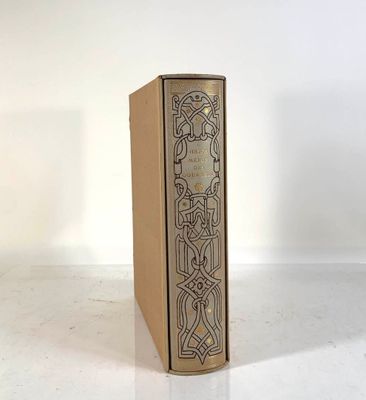 un vieux livre posé sur une table à côté d'un mur blanc