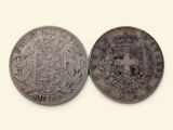 une vieille pièce de monnaie sur laquelle figurent des armoiries et une couronne
