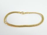 a gold bracelet with a braid design on a white background