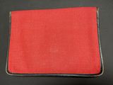 a red and black wallet sitting on top of a black table