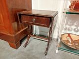 a small wooden table with a glass shelf next to it