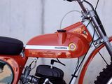 a red motorcycle parked next to a white wall