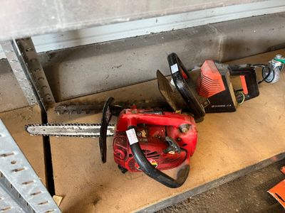 two chainsaws that are sitting on the ground