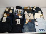 plusieurs paires de jeans sont disposées sur une table