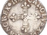 an old silver coin with a cross on it