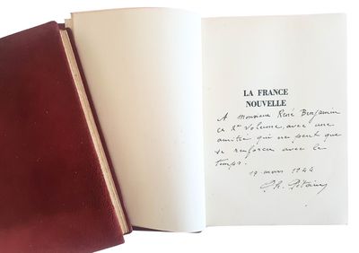 un livre ouvert, sur lequel est posée une note manuscrite, posé sur une table