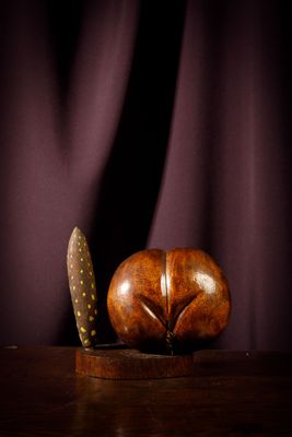 un objet en bois surmonté d'un couteau, posé sur une table