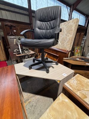 une chaise de bureau noire posée sur une table en bois