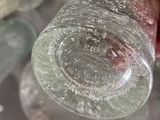 a person holding a glass bottle with a lot of water inside of it