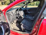 the interior of a red car with the door open and the driver ' s seat up