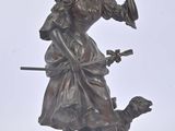 bronze statue of a woman with a dog on a white background