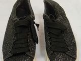 black glittered sneakers with white soles on a white surface