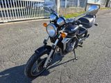 a motorcycle that is parked on the street in front of a fence