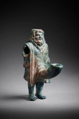 une ancienne figurine en bronze représentant un homme tenant un poisson