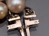 a close up of a necklace with a cross on it
