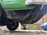 a green car that is parked on the side of the street