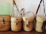 trois tasses en osier et un porte-verre posés sur une table en bois