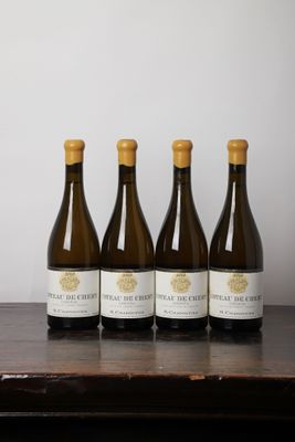 quatre bouteilles de vin sont alignées sur une table