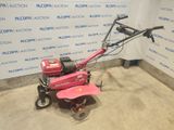 an image of a pink lawn mower parked in a room