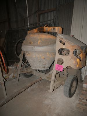 a cement mixer sitting in a garage next to a pile of pallets