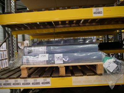 many rolls of plastic on a pallet in a warehouse