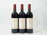 trois bouteilles de vin rouge posées côte à côte sur une table