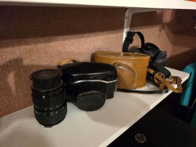 une étagère sur laquelle se trouvent un appareil photo, un étui pour appareil photo et un appareil photo