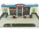 une petite maquette de station-service posée sur une surface blanche