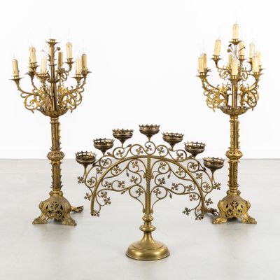 a set of four brass candelabs with candles on them
