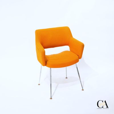 une chaise orange posée sur un sol blanc, à côté d'un mur blanc