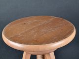 a wooden stool with a wooden seat on a black background