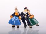 two figurines of a man and a woman sitting on a bench
