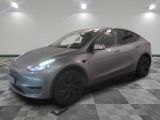 Le SUV Tesla argenté est garé sur un sol à damier.