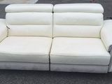 a white leather couch that is sitting on the street