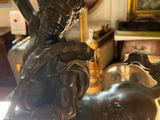 a bronze statue of a man riding a horse