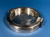 a silver plate with a handle on a blue surface