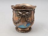 a silver vase that is sitting on a table