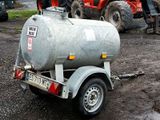 a trailer with a tank attached to it in the dirt
