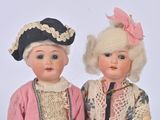 two dolls that are standing next to each other