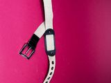 a white strap with a black buckle on a pink background