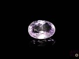 a close up of a purple gemstone on a black surface