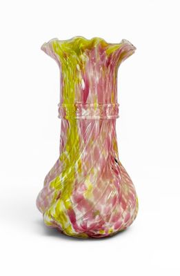 un vase rose et jaune posé sur une surface blanche
