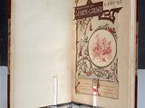 an open book on a table with a candle on it